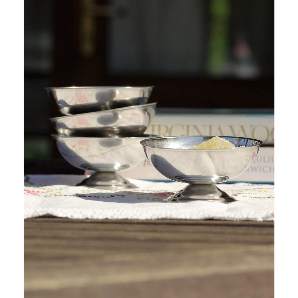 A stack of stainless steel ice cream cups on the table.